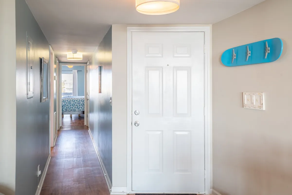 This image features the front door with skateboard wall decor and a modern light fixture, immediately creating an inviting and stylish first impression. The crisp and clean entryway is well-lit, signaling a welcoming and easy arrival experience.
